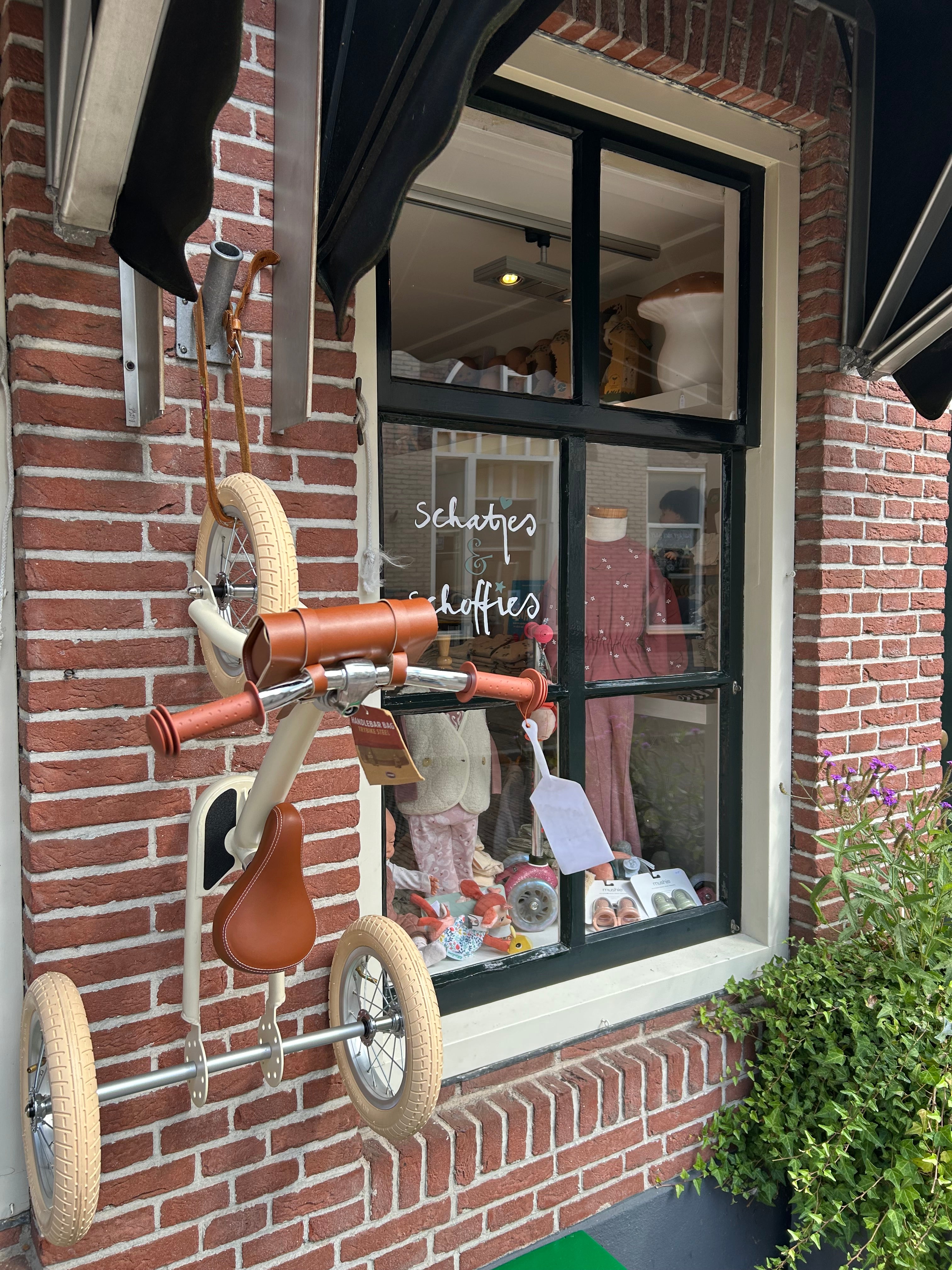 Vooraanzicht van conceptstore Schatjes en Schoffies in Wijk bij Duurstede, een sfeervolle winkel met kleding, speelgoed en accessoires voor baby’s en kinderen. Etalage en Trybike