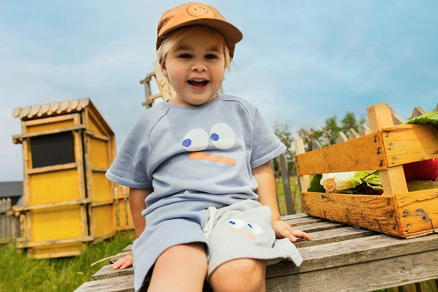 Jongen met een Sproet & Sprout Terry Bermuda Shorts Colourblock aan en pet op
