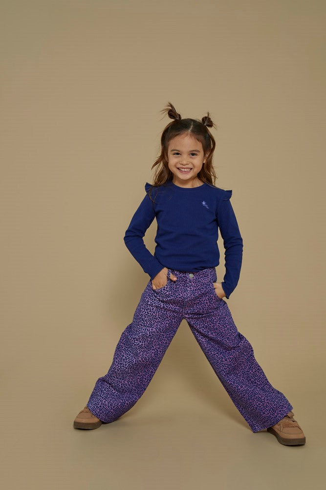 Jubel Flared Broek AOP - Wild Soul Sfeerfoto: "Kind draagt de Jubel Flared Broek AOP - Wild Soul in L.Lila, met vrolijke all-over print, perfect voor een winterwandeling of een speelse schooloutfit."