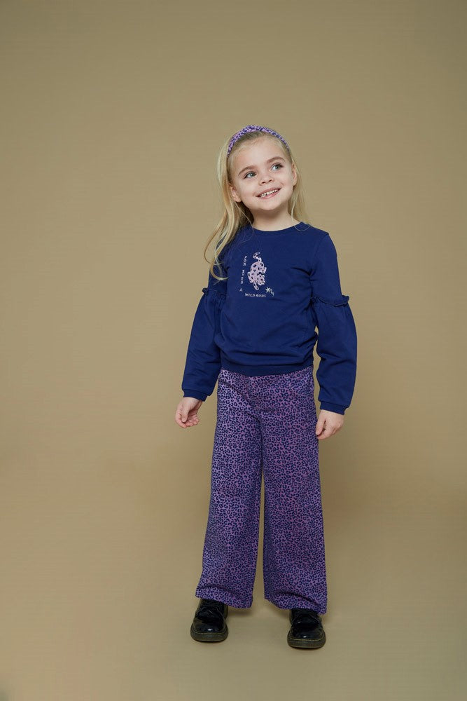 Jubel Flared Broek AOP - Wild Soul Sfeerfoto: "Kind draagt de Jubel Flared Broek AOP - Wild Soul in L.Lila, met vrolijke all-over print, perfect voor een winterwandeling of een speelse schooloutfit."