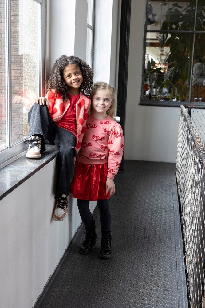 Jubel Rok - Queen Of Hearts Sfeerfoto: "Kind draagt de Jubel Rok - Queen Of Hearts in Rood, met een romantisch hartontwerp, ideaal voor een winterfeest of casual gelegenheid."