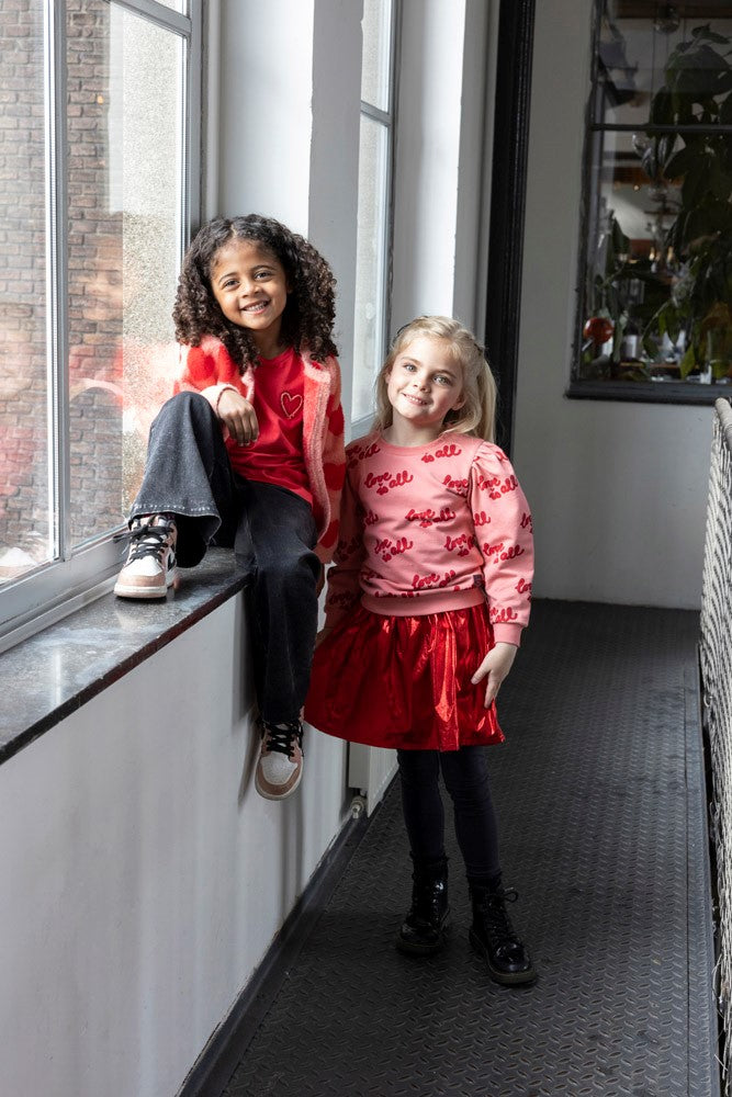 Jubel Rok - Queen Of Hearts Sfeerfoto: "Kind draagt de Jubel Rok - Queen Of Hearts in Rood, met een romantisch hartontwerp, ideaal voor een winterfeest of casual gelegenheid."