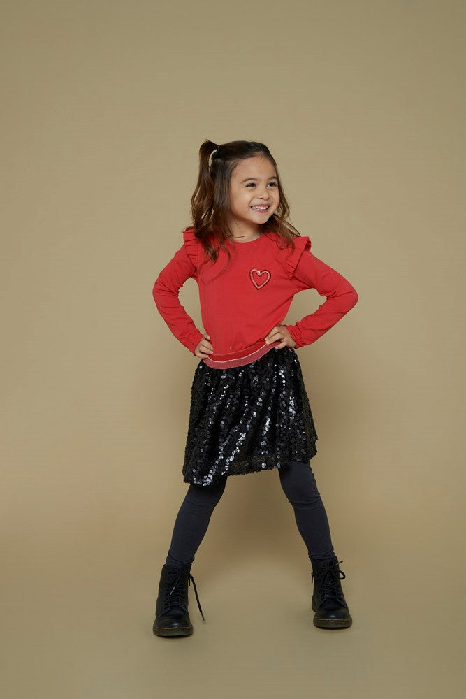 Jubel Longsleeve - Queen Of Hearts Sfeerfoto: "Kind draagt de Jubel Longsleeve - Queen Of Hearts in Rood, met een speelse hartprint, perfect voor een casual winteroutfit."