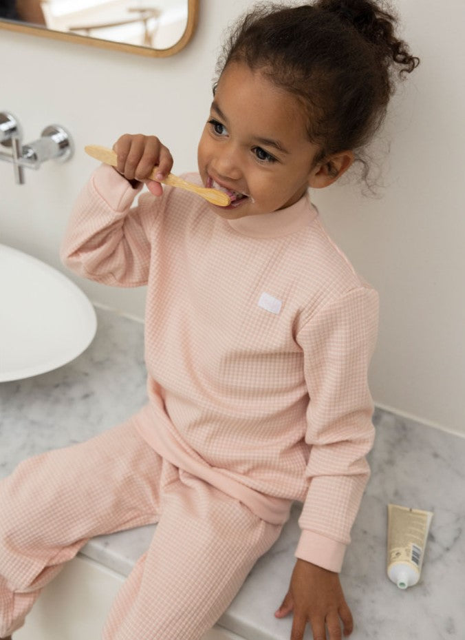 Feetje Wafelpyjama roze meisje poetst tanden