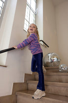 Kind draagt de Jubel Sweater AOP - Wild Soul in Violet met all-over print, in een avontuurlijke setting, Wintercollectie 2025.