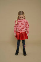 Jubel Rok - Queen Of Hearts Sfeerfoto: "Kind draagt de Jubel Rok - Queen Of Hearts in Rood, met een romantisch hartontwerp, ideaal voor een winterfeest of casual gelegenheid."