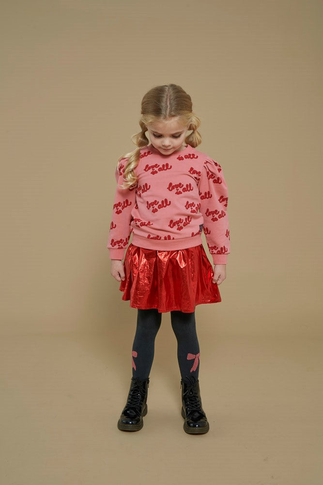 Jubel Rok - Queen Of Hearts Sfeerfoto: "Kind draagt de Jubel Rok - Queen Of Hearts in Rood, met een romantisch hartontwerp, ideaal voor een winterfeest of casual gelegenheid."